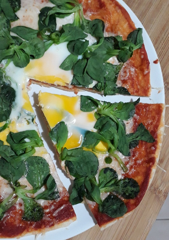 Una foto de Pizza con rúcula y huevo