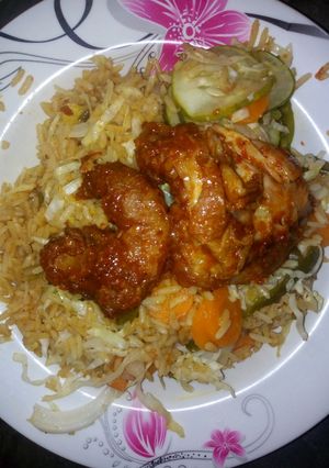 A picture of Jallof rice with cucumber and peper meat.