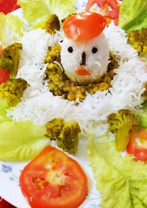 A picture of Egg shaped rice with dal and stir fried broccoli and tomato.