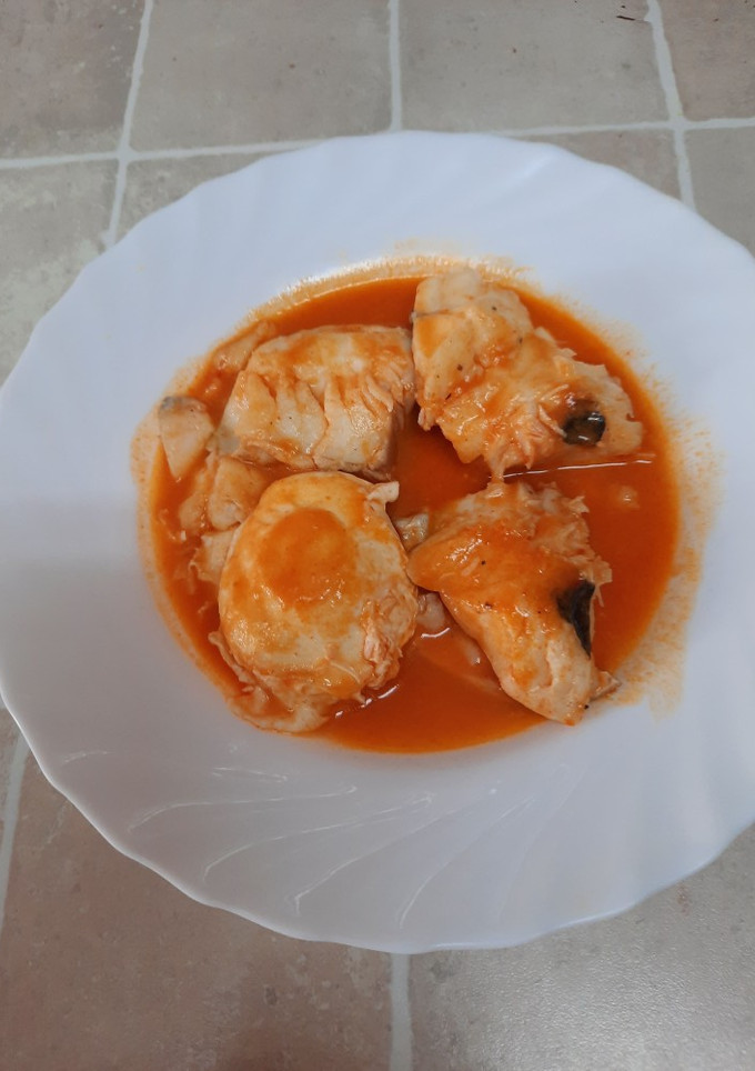 Una foto de Filetes de merluza en salsa de pimientos de piquillo con huevo