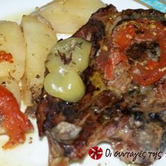 A picture of Pork chops with potatoes in a casserole dish.