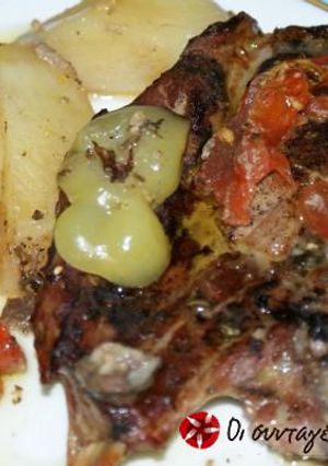 A picture of Pork chops with potatoes in a casserole dish.