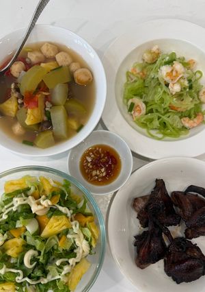 Hình của món Cơm nhà với chim bồ câu nướng mật ong, bí xanh xào tôm, canh hến cá viên nấu chua, salad kiwi táo.
