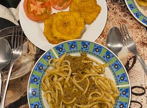 Una foto de Spaghetti con carne de Murillo con patacones y tomates con orégano 🌿