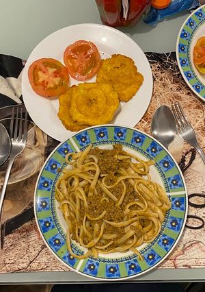 Una foto de Spaghetti con carne de Murillo con patacones y tomates con orégano 🌿