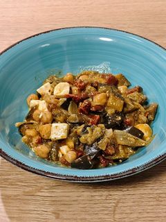 Una foto de Wok de berenjena con garbanzos, tomate seco y queso feta