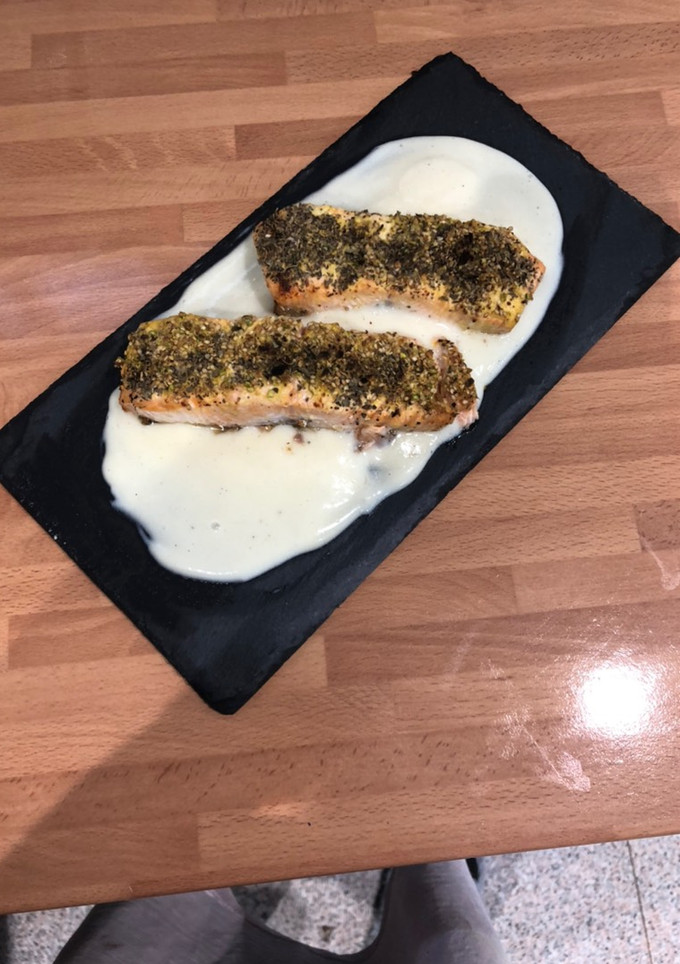 Una foto de Salmón al horno con crujiente de pistacho y sésamo sobre crema de coliflor