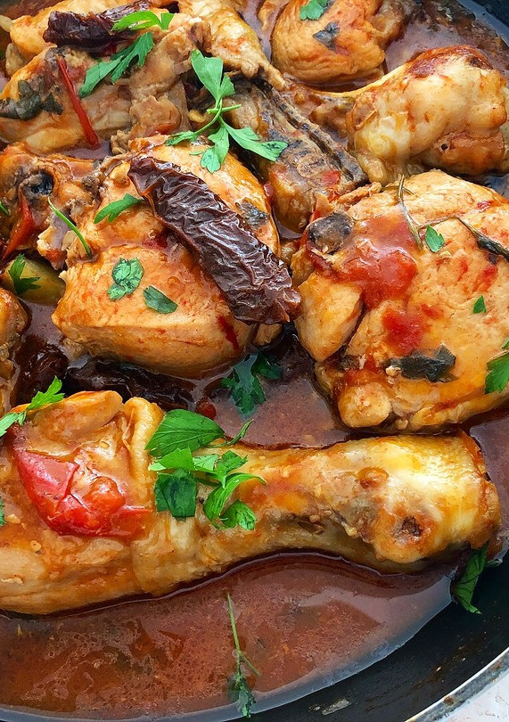 Una foto de Pollo rustido con tomates y pimentón
