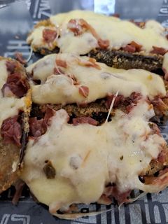 Una foto de Milanesas de berenjenas con una salsa de vegetales al horno