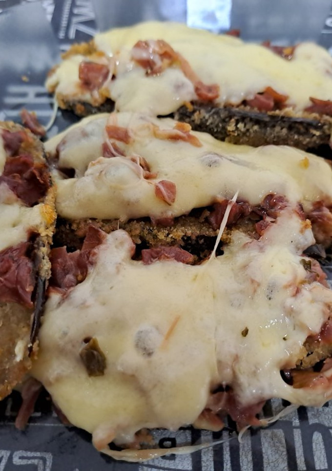 Una foto de Milanesas de berenjenas con una salsa de vegetales al horno