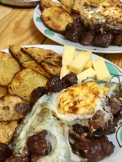 Una foto de Butifarras con salsa de vino tinto, patatas al horno y huevos