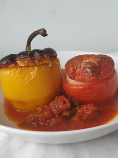 Una foto de Pimientos y tomates rellenos de arroz en salsa de tomate al horno al estilo griego