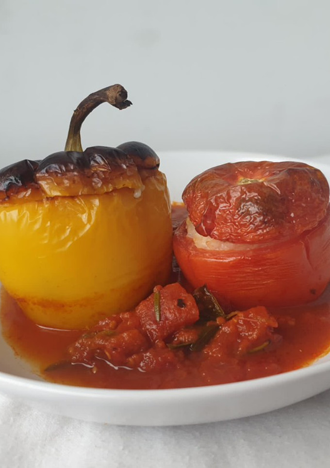 Una foto de Pimientos y tomates rellenos de arroz en salsa de tomate al horno al estilo griego