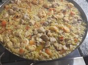Una foto de paella de pollo y cerdo