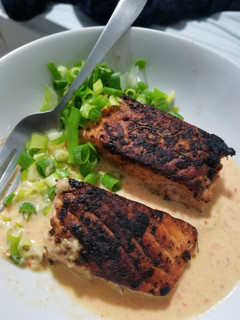 A picture of Pan roasted Salmon with creamy red pepper and jalapeno sauce.