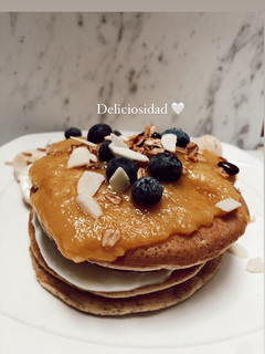 Una foto de Pancakes 🥞 de harina de almendra y coco, salsa de mango 🥭 en sartén, arándanos y yogurt de vainilla🤤