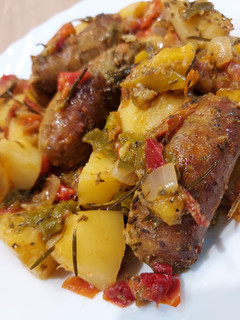 Une photo de Saucisses pommes de terre, poivrons et tomates au four