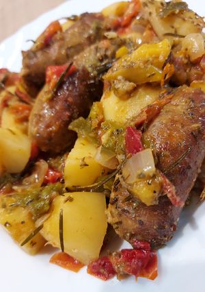Une photo de Saucisses pommes de terre, poivrons et tomates au four