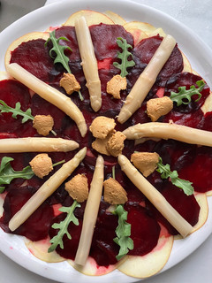 Una foto de Ensalada de espárragos blancos sobre carpaccio de manzana y remolacha