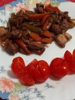 Una foto de Bocaditos de pollo al vino con verduras y tomatitos cherry
