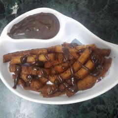 A picture of Fried bread sticks with homemade chocolate sauce.