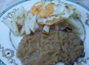 Una foto de Milanesas al horno con fritas a caballo