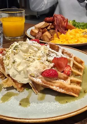 Una foto de Gofres con nata, fresas y pistachos