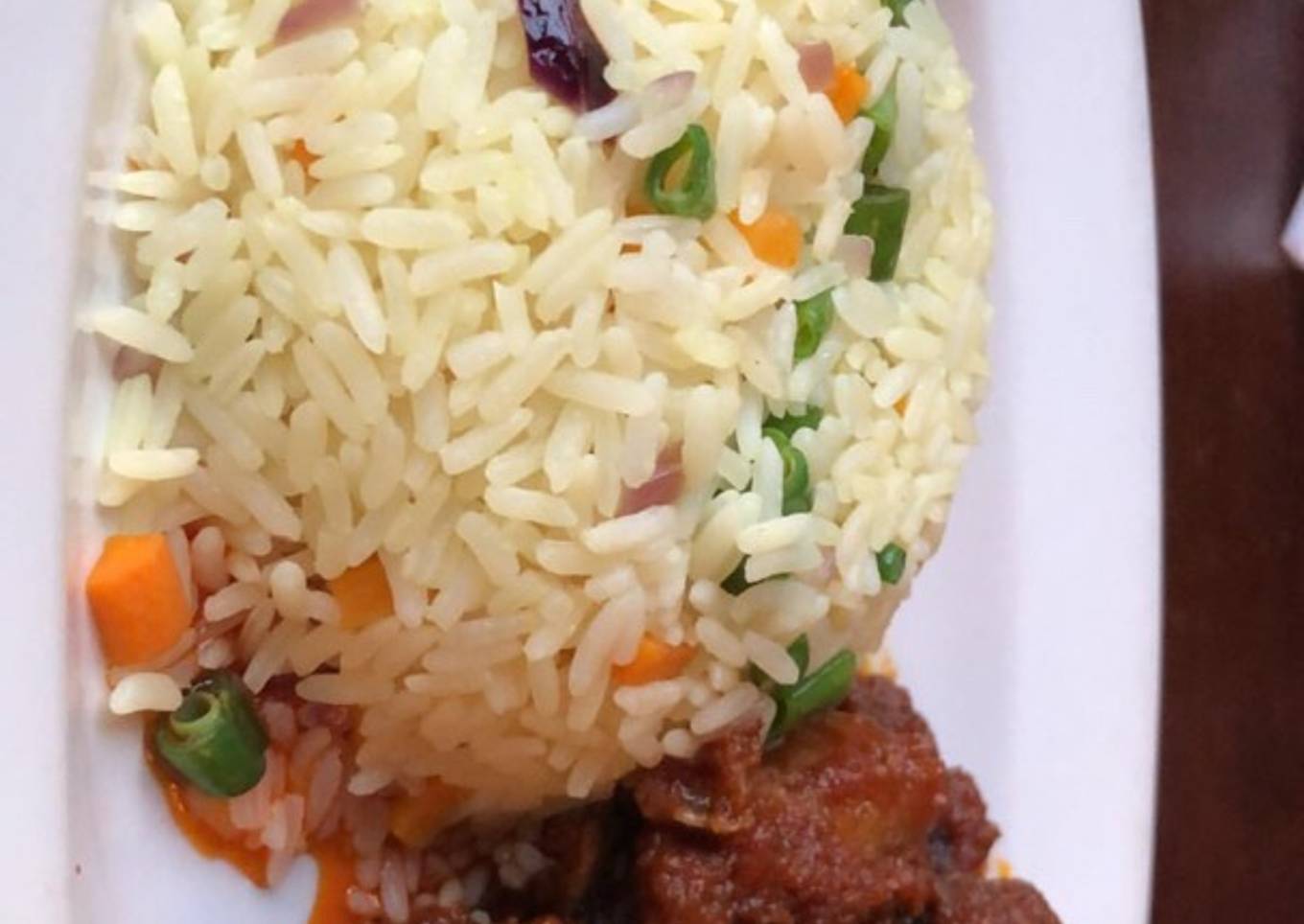 Fried rice and goat meat sauce and fried plantain