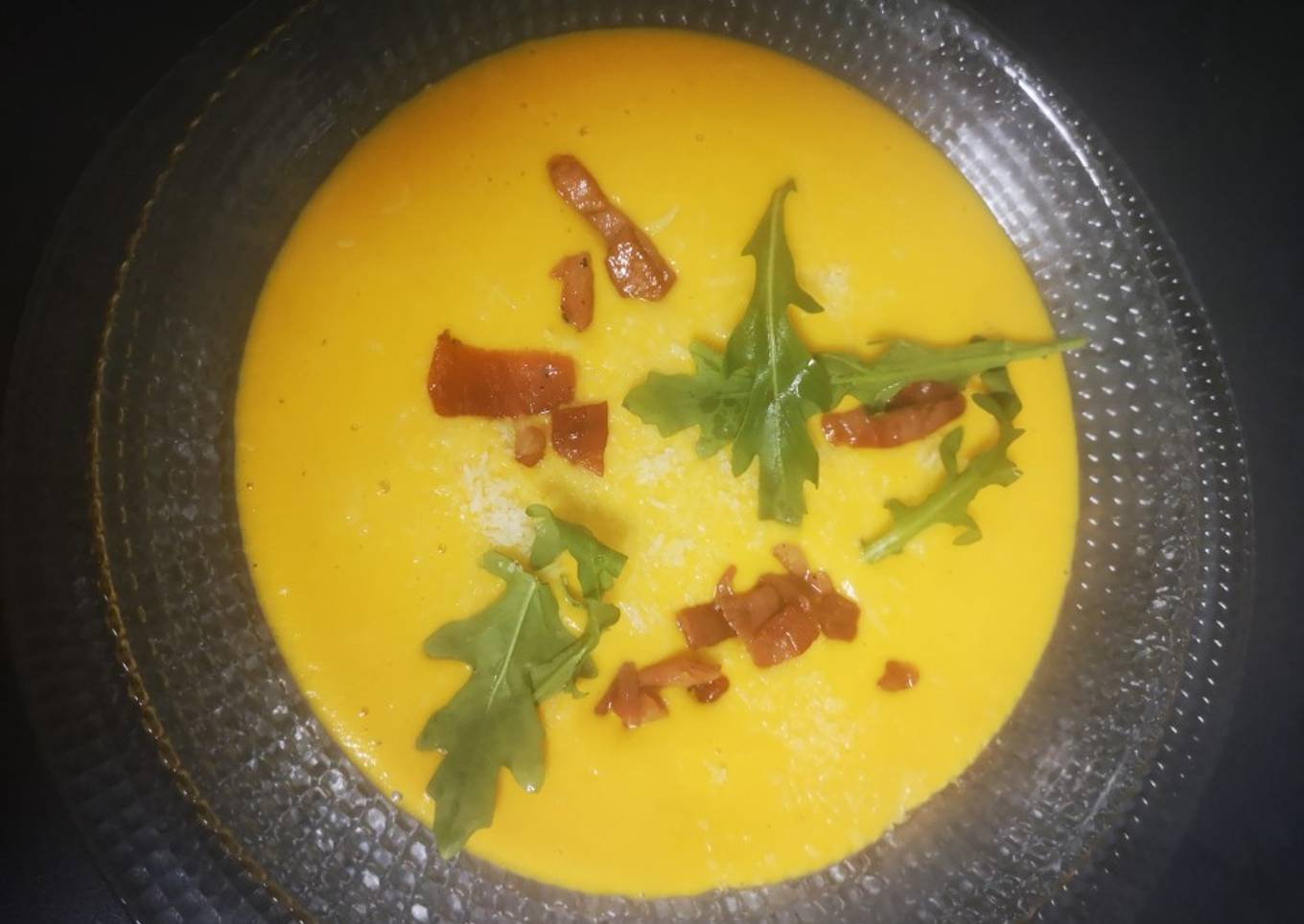 Crema de zanahoria, con rúcula, parmesano y picatostes de jamón