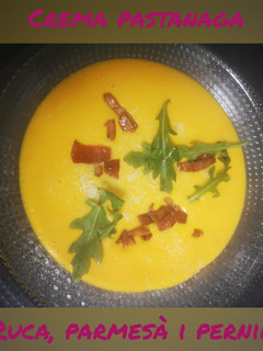 Una foto de Crema de zanahoria, con rúcula, parmesano y picatostes de jamón