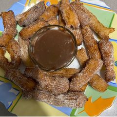 A picture of Churros with chocolate sauce.