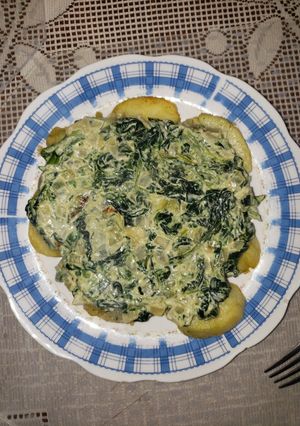 Una foto de Espinacas a la crema con papas doradas