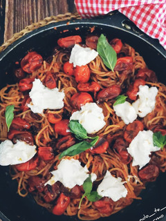 Una foto de Espaguetis al pesto rosso, cherrys confitados y burrata