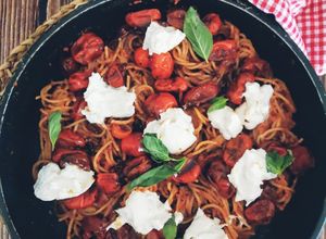 Una foto de Espaguetis al pesto rosso, cherrys confitados y burrata