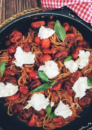 Una foto de Espaguetis al pesto rosso, cherrys confitados y burrata
