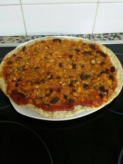 Una foto de Una pizza rellena de bacalao y pasas