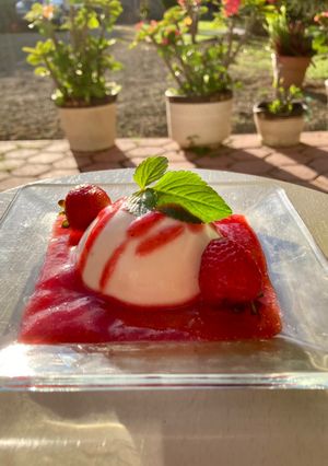 Una foto de Panna cotta con coulis de fresa