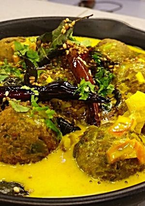 A picture of Mattar kofte stuffed with apricot in coconut gravy.