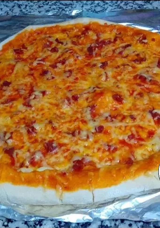 Una foto de Pizza casera con borde de queso (de jamón) - no más masa pegada✋