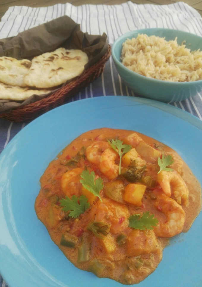 Una foto de Curry rojo de langostinos y mango con arroz jazmín