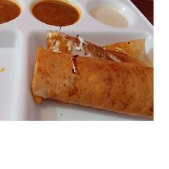 A picture of Masala dosa with sambhar.