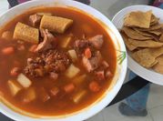 Una foto de sopa de lentejas con jamón