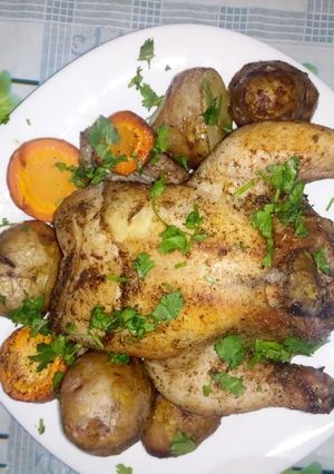 A picture of Baked Rosemary chicken with carrots and potatoes.