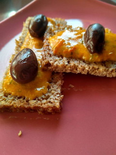 Una foto de Aperitivo vegano. Mojo rojo con aceitunas y pan de centeno