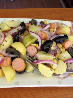Una foto de Ensalada de patatas nuevas con Frankfurt de pollo, maíz, uvas negras y cebolla morada