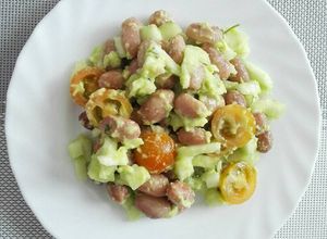Una foto de Ensalada de frijoles, cohombro, tomate con aderezo de guacamole
