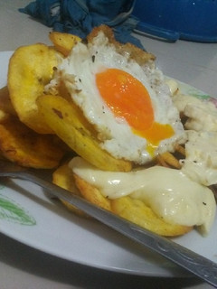 Una foto de Tajadas de plátano acompañado de caviar y queso derretido