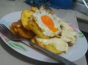 Una foto de Tajadas de plátano acompañado de caviar y queso derretido
