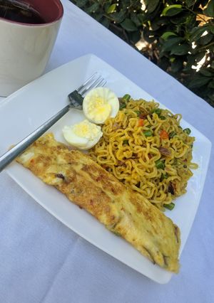 A picture of Stir fry noodles with egg omelette and boiled egg.