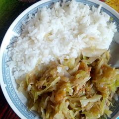 A picture of Rice served with fried cabbage.